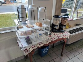 A bakery display with bread, pastries, and coffee machines.