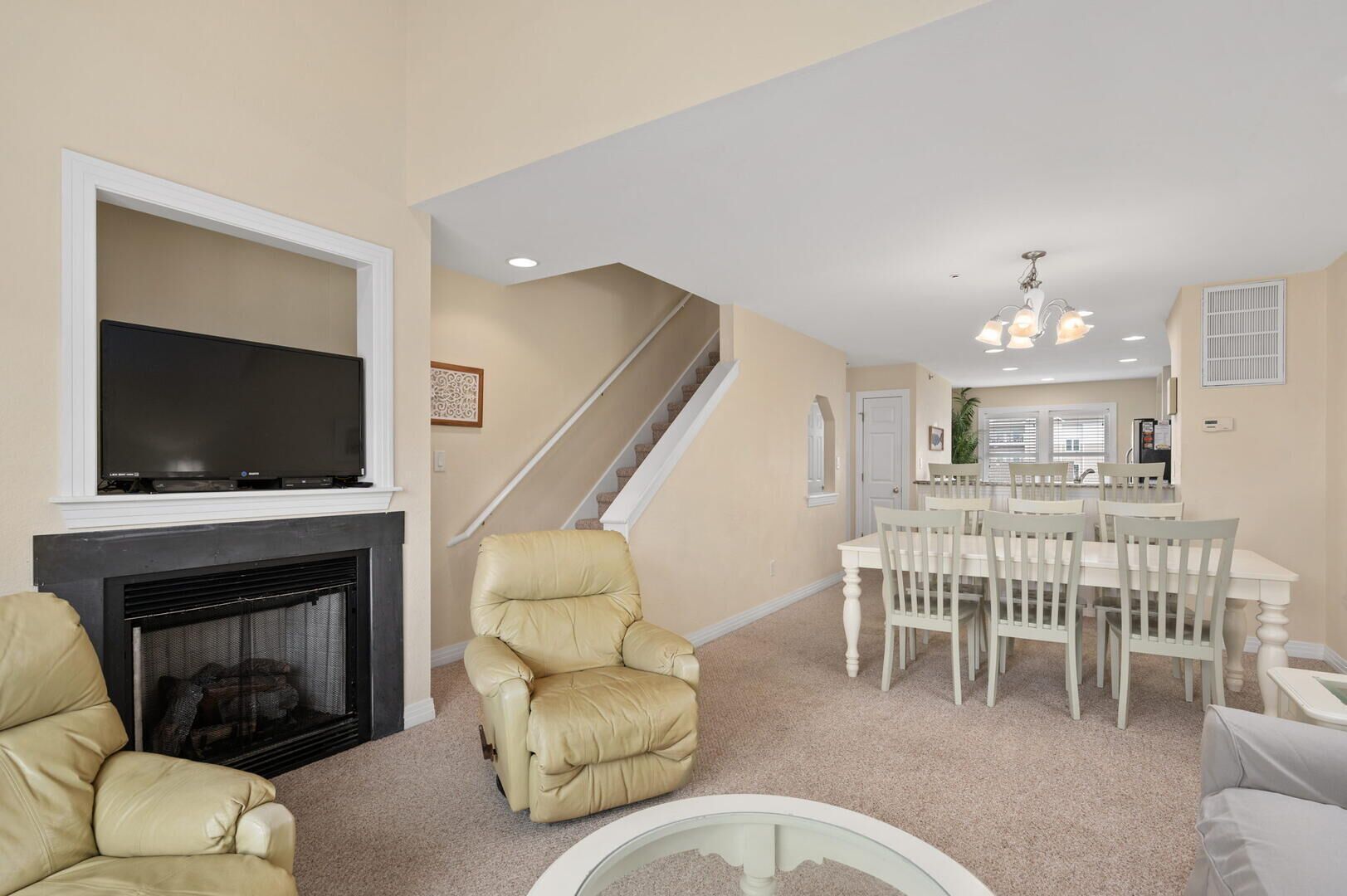 A living room with a fireplace, a television, and a dining area with a table and chairs.