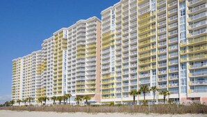 Un hôtel de grande hauteur doté de nombreux balcons, situé près d’une plage.