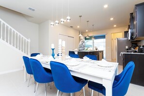 A modern kitchen with dark cabinets, a white countertop, and a stainless steel refrigerator.