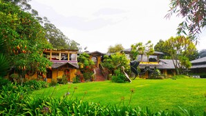 A traditional house with a well-maintained garden, a staircase leading to the entrance, and a water feature.