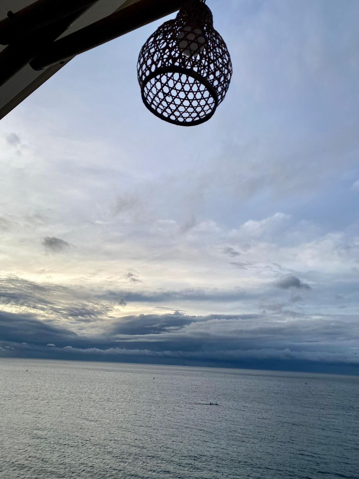 Une vue sur la mer avec un luminaire suspendu.