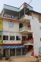 A multi-story building with a sign reading "HOTEL VIJAY".