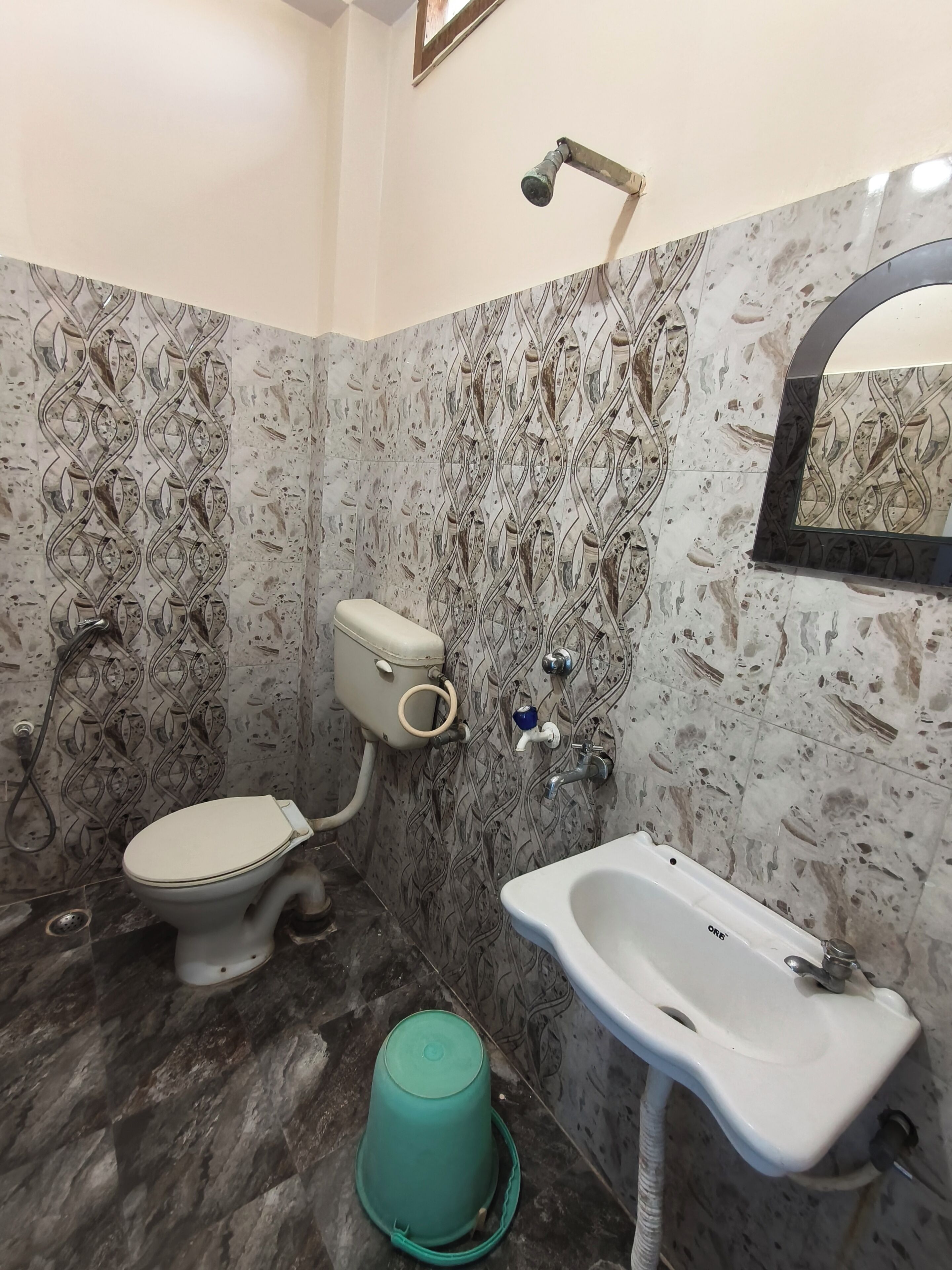 A bathroom with a toilet, sink, and shower.