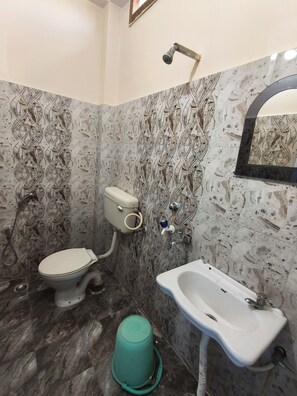 Une salle de bain avec des toilettes, un lavabo et une douche.