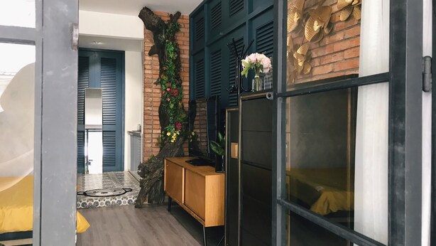 A modern interior with a brick wall, a wooden cabinet, and a glass door. - Sweetheart in Saigon - 5mins to the Notre Dame Saigon (Thành phố Hồ Chí Minh)