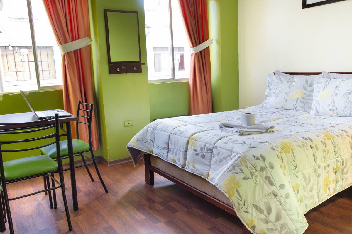 A room with a bed, a desk, and a chair.