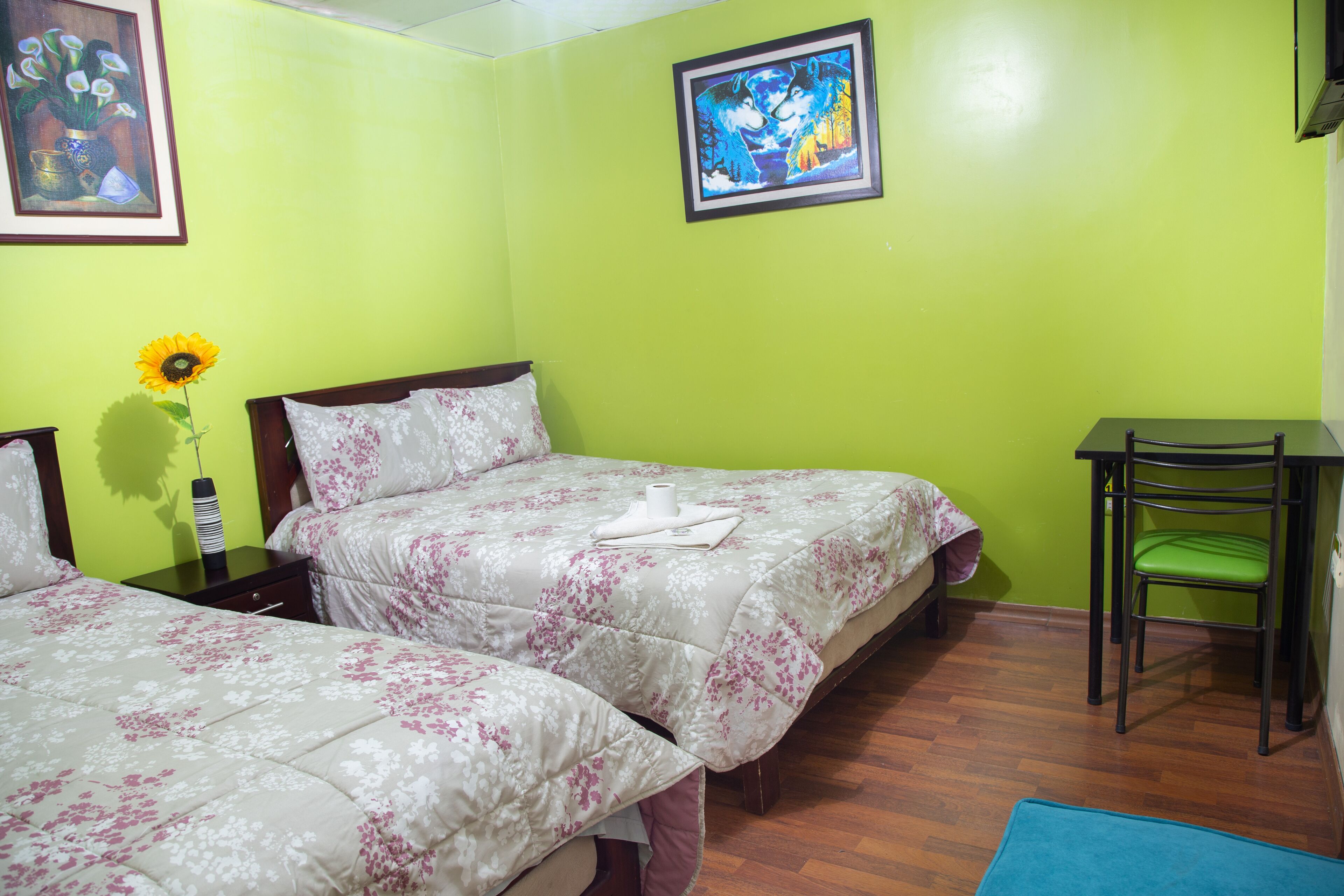 A room with two beds, a desk, and a chair.