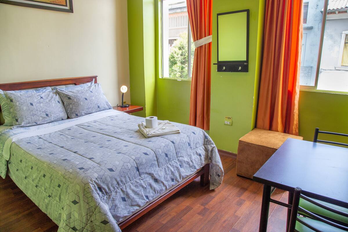 A room with a bed, a table, and a chair.