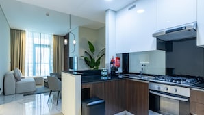 Una cocina moderna con una isla central, electrodomésticos integrados y un rincón comedor con sofá y sillas.