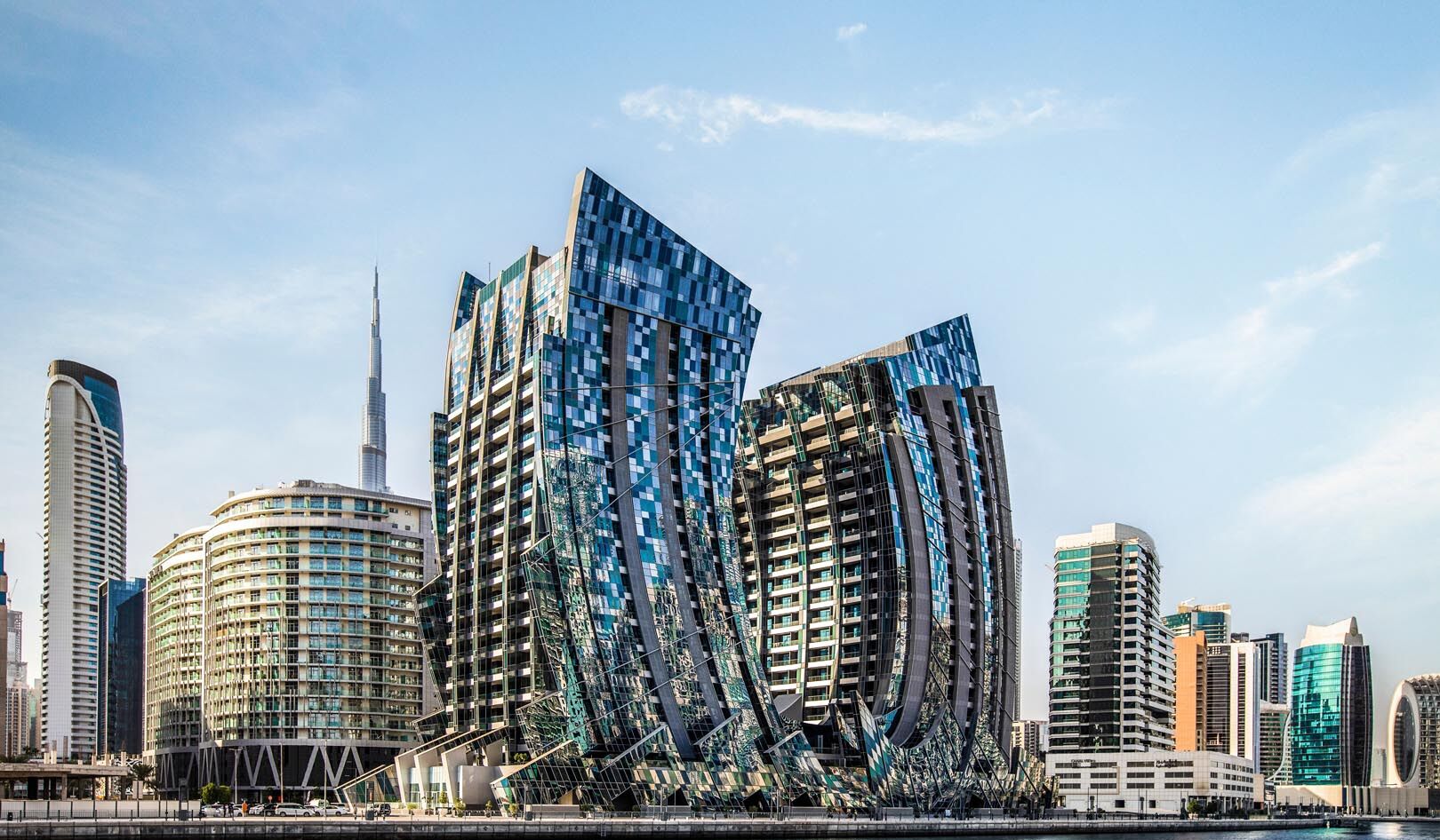 A modern cityscape with distinctive skyscrapers, including a prominent curved building and a tall, slender tower.