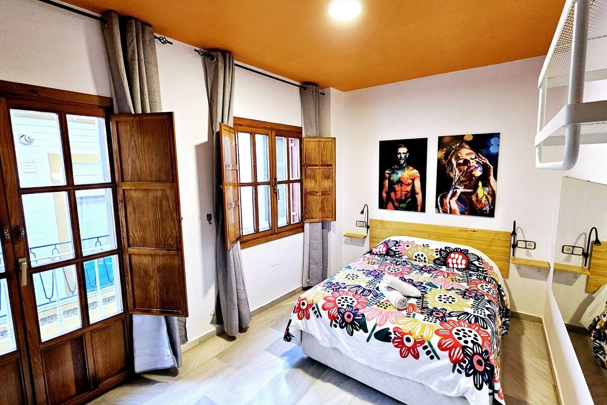 A bedroom with a bed, a window, a wardrobe, and a ceiling light.