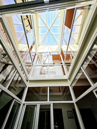 A modern building with a glass atrium, multiple floors, and a visible staircase.