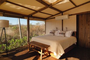 A bedroom with a wooden bed, a bench, an air conditioning unit, and a lamp. - Viatura Hacienda Xtojil, Yucatan, Merida, with Optional All Inclusive (Timucuy)