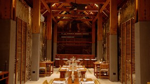 A long dining table set for a meal in a room with wooden beams and a high ceiling. - Viatura Hacienda Xtojil, Yucatan, Merida, with Optional All Inclusive (Timucuy)