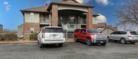Un edificio de varios pisos con un estacionamiento al frente.