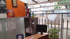 A reception desk with a computer monitor, a framed certificate, and a sign indicating a 8.6 guest review. - Hostal Whipala (Quito)