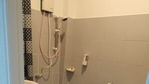 A small bathroom with a toilet, a sink, and a shower. - Kata S.T House 2 (Karon)