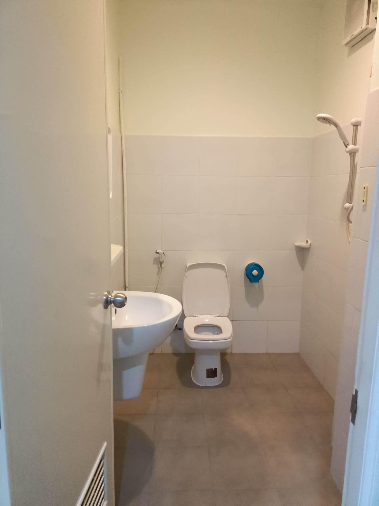 A small bathroom with a toilet, a sink, and a shower.