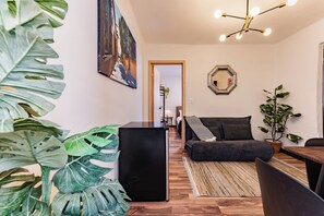 Un salon moderne avec une table basse noire, un canapé foncé et un plancher en bois.