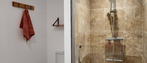 Ein Badezimmer mit Dusche, Toilette und Handtuchhalter.