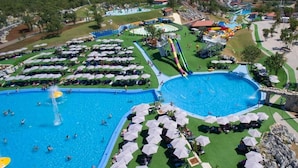 Ein Resort mit mehreren Swimmingpools, Wasserrutschen und Sonnenschirmen.