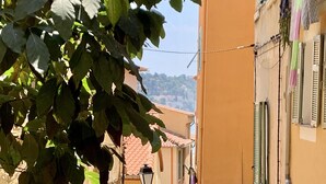 Un carrer estret amb edificis a ambdós costats, un rètol per al restaurant 'La Belle Etoile' i un rètol 'LE SERE'.