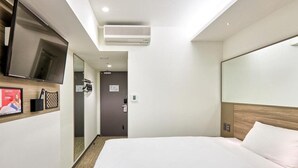 A hotel room with a large bed, a flat-screen TV mounted on the wall, and a small desk area. - Red Planet Sapporo Susukino Central (Sapporo)