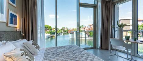 Une chambre d’hôtel avec un grand lit, un bureau et une vue sur une piscine et des immeubles.