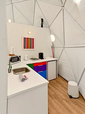 A compact kitchen with a microwave, toaster, and sink. - Glamp Camp (Waterborough)