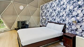 A bedroom with a bed, a nightstand, a dresser, a heater, and a wall with a floral pattern.