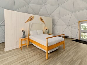 A bedroom with a wooden bed, white walls, and a geometric ceiling design. - Glamp Camp (Waterborough)