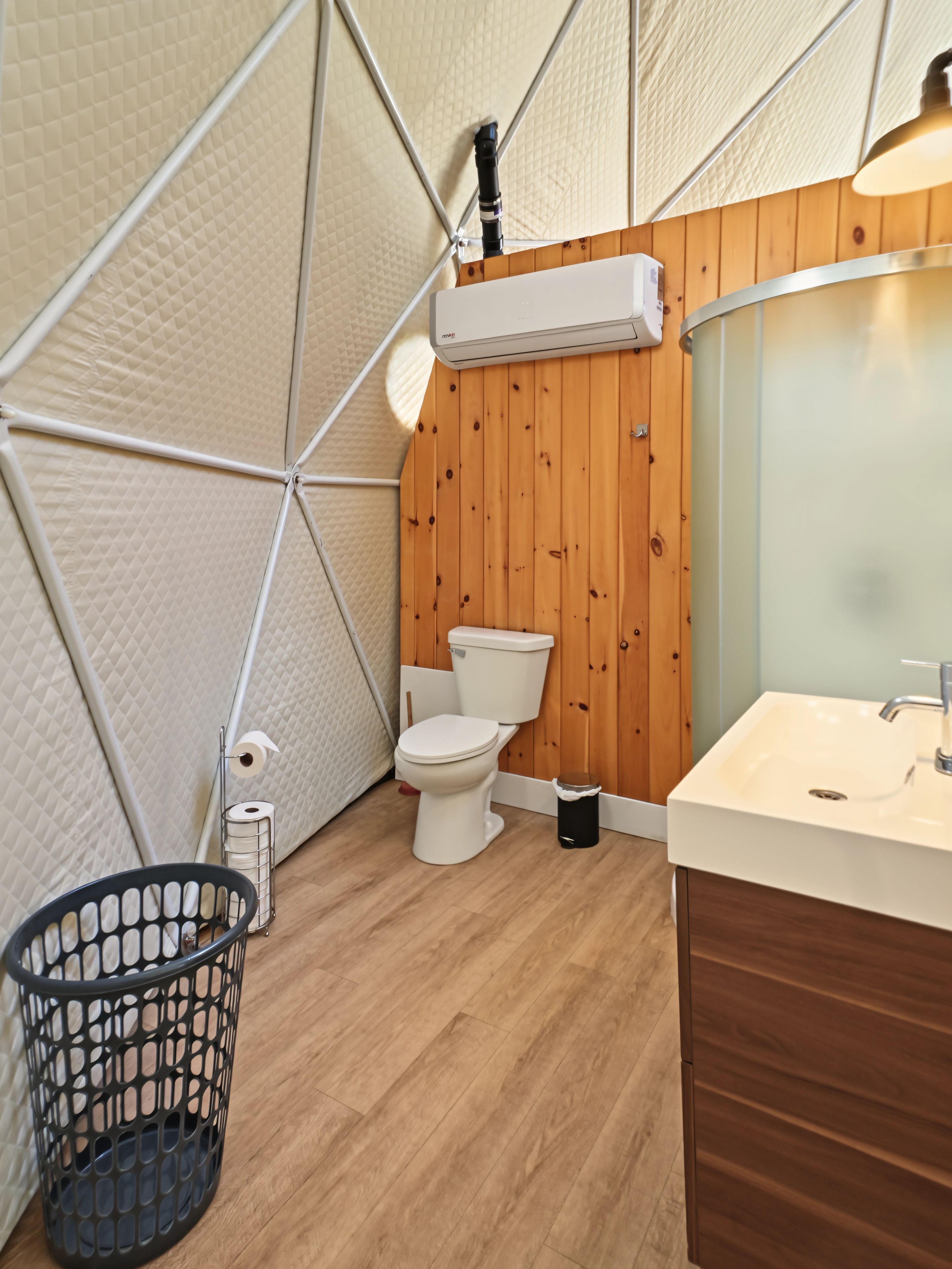 A compact, modern bathroom with a toilet, sink, and storage cabinet.
