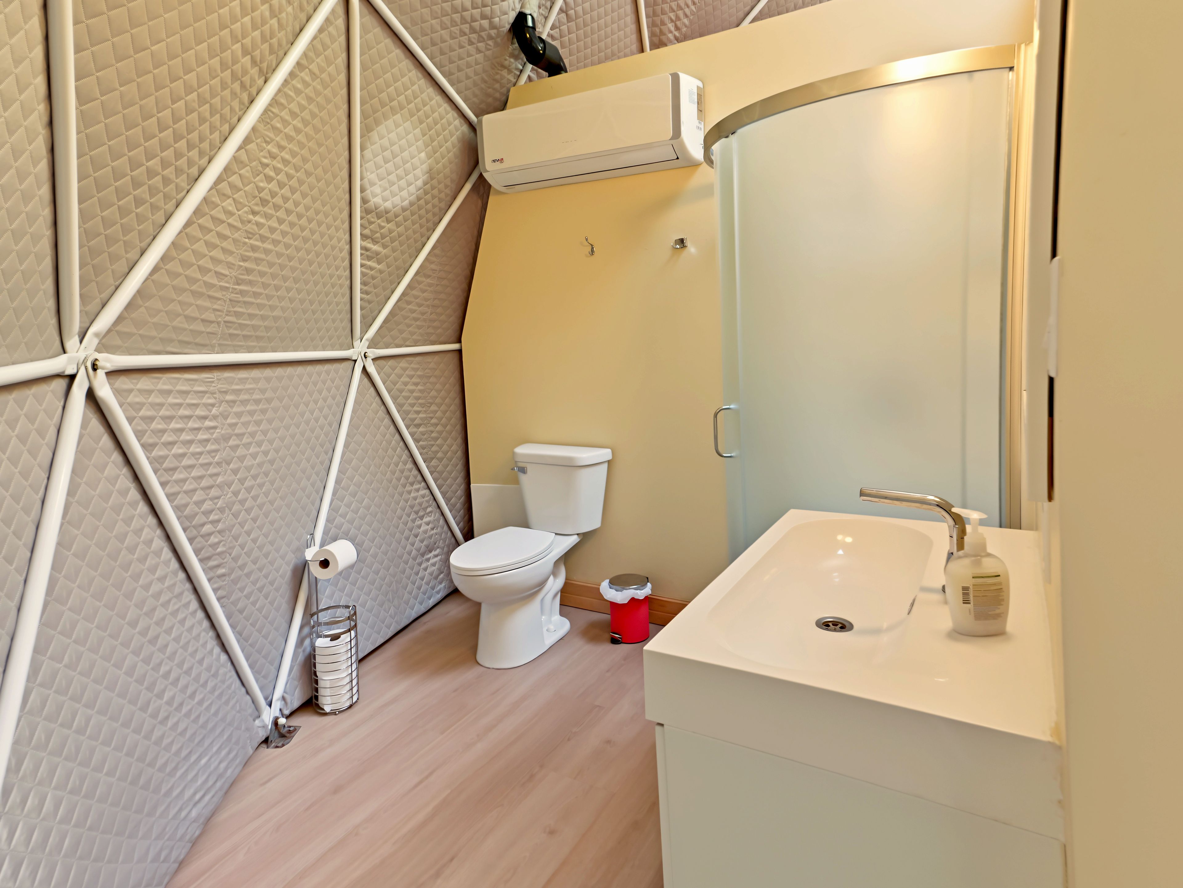 Een kleine badkamer met toilet, wastafel en spiegel.