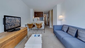 A modern living room with a TV, sofa, and dining area. - Very pretty apartment, well located, great view (Val-d'Isère)