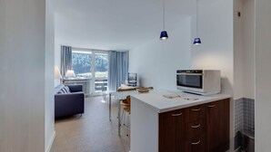 A modern kitchen with a microwave, wooden cabinets, and pendant lights. - Very pretty apartment, well located, great view (Val-d'Isère)
