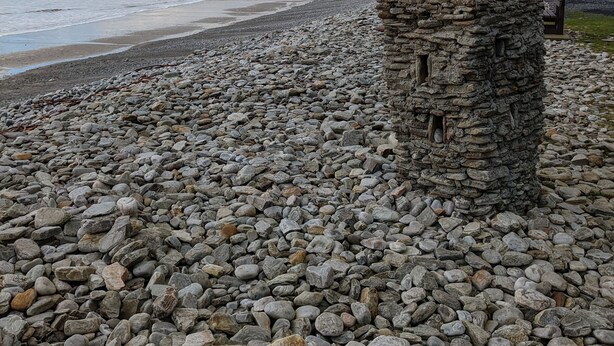 Una playa rocosa con una estructura de piedra.