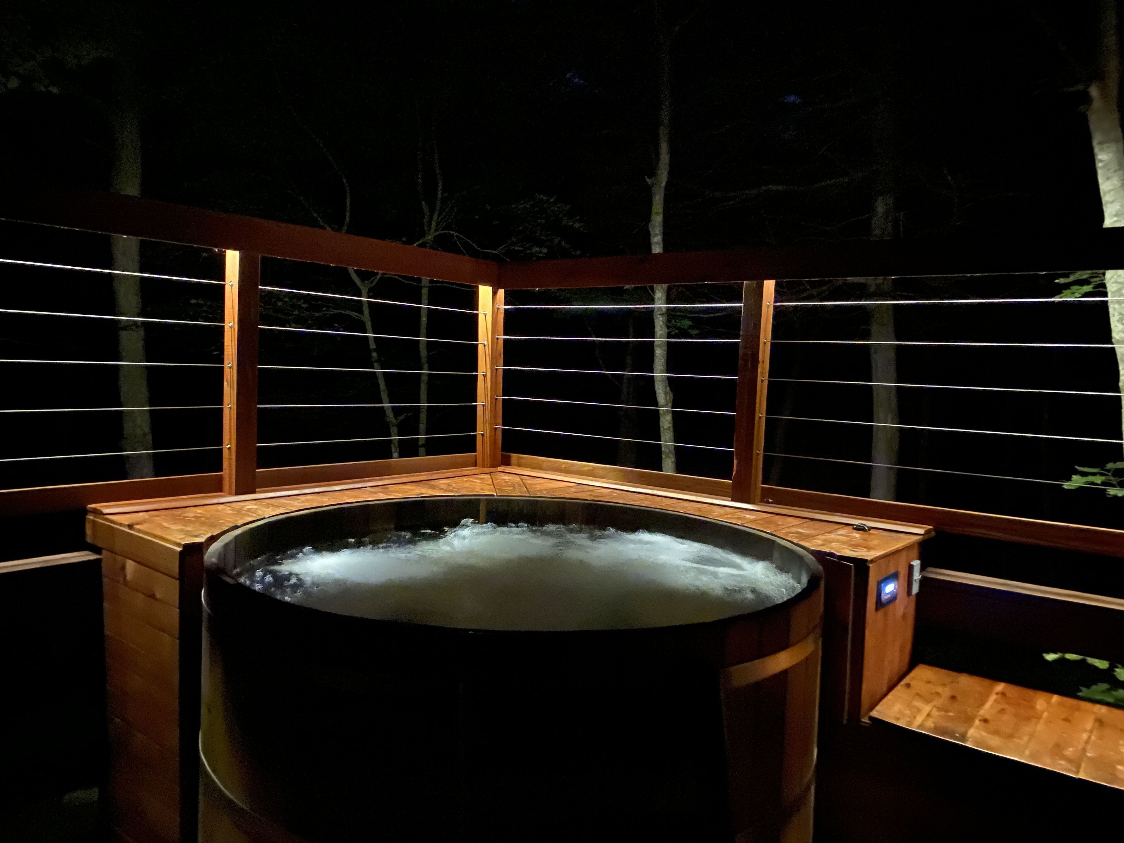 A hot tub with wooden benches and a wooden fence.