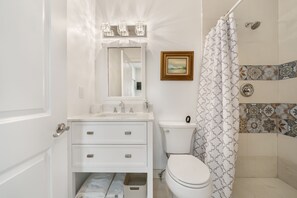 Een douche, handdoeken, zeep, toiletpapier