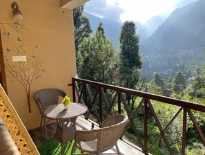 Un balcon doté de meubles en osier et offrant une vue sur les montagnes.