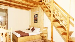 Un dormitorio de madera con cama, mesita de noche y una escalera de madera.