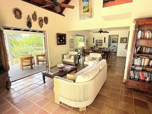 A spacious living room with a sofa, chairs, a coffee table, and a bookshelf.