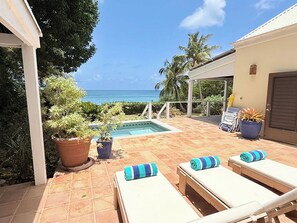 A pool area with lounge chairs and potted plants.