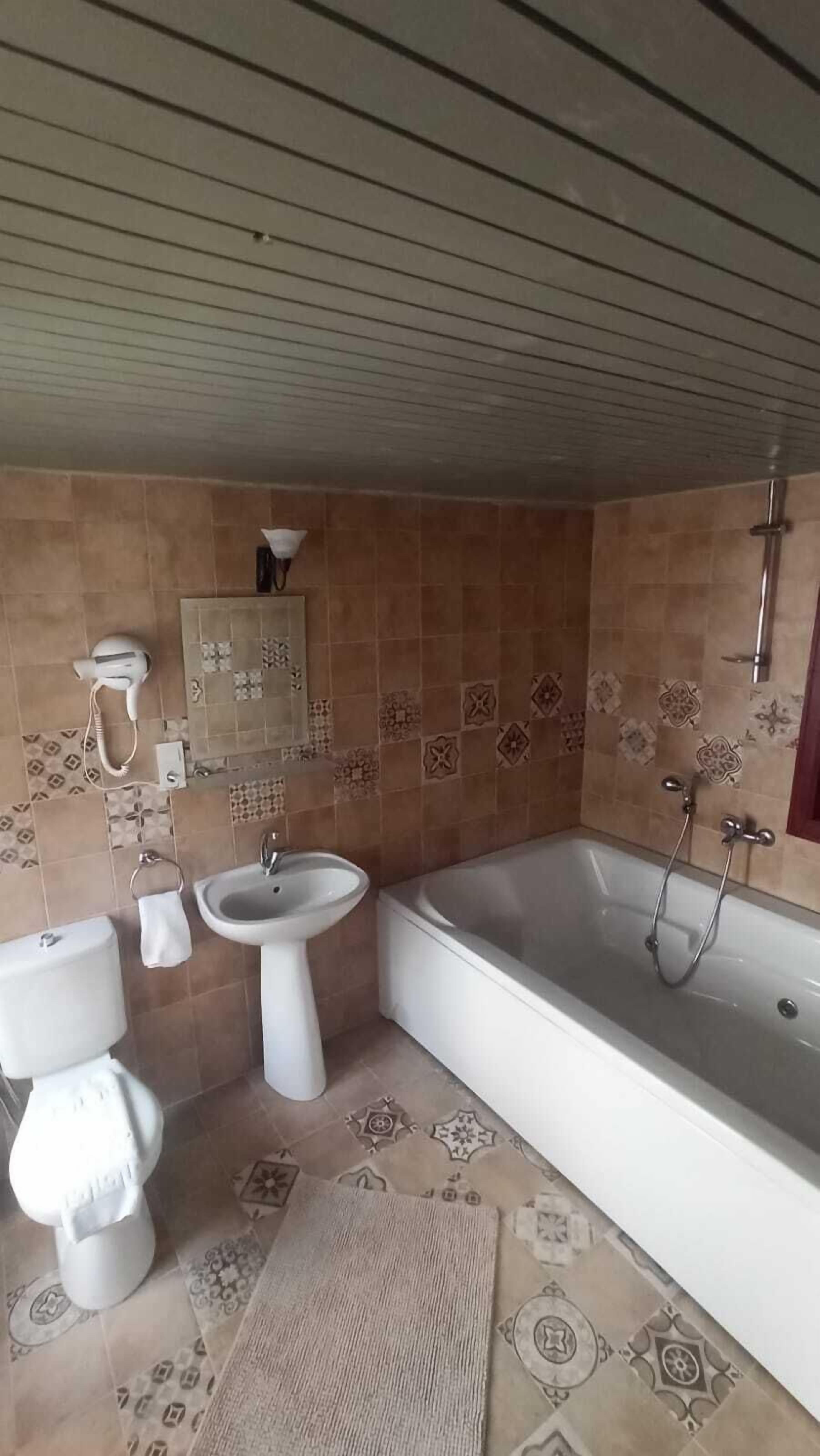 A bathroom with a toilet, bidet, sink, and bathtub.