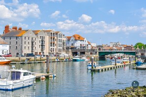 A harbor with boats docked, a bridge, and buildings along the waterfront. - Cobb Cottage - Harbourside, permit parking (Weymouth)