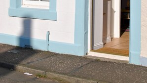 A building with a white exterior and blue trim around the windows and door. - Sea Whisper- lovely home in charming village (Pittenweem)
