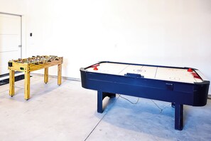 Two foosball tables in a room with a white door and light-colored walls. - Top Rated • Luxe • Spotless • Quiet • Prime Area by The Village at Meridian (Meridian)