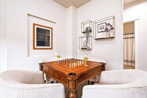 A dining table with a chessboard, two glasses of wine, and framed artwork on the walls. - Top Rated • Luxe • Spotless • Quiet • Prime Area by The Village at Meridian (Meridian)