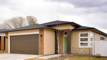 Einbungalow mit Garage, Eingangstür und kleiner Veranda.