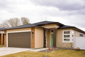 Einbungalow mit Garage, Eingangstür und kleiner Veranda.